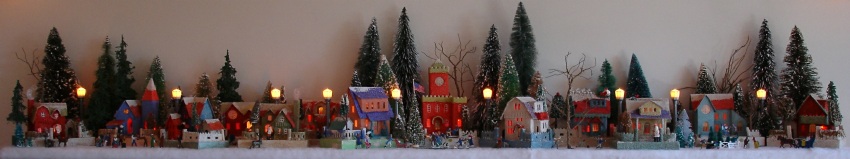 Antique Christmas cardboard house putz (village) on fireplace mantel in 
the daytime (50K)